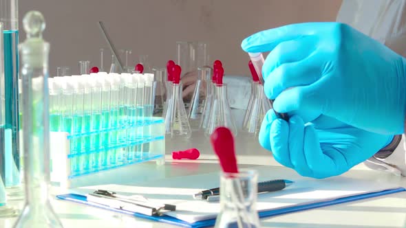 Close Up Footage - Doctor Holds a Test Tube with a Blood Sample. alt