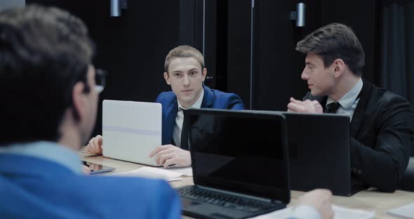 Colleagues at Work Talk in the Meeting Room. Businessmen Are Discussing Company Plans