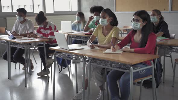 Group of Multiethnic Teenager High School Students Wearing Medical Face Masks During Class at the