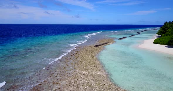 Wide above travel shot of a white sandy paradise beach and blue water background in high resolution 