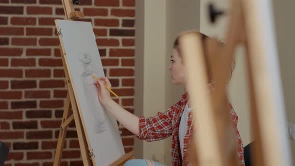 Portrait of Young Woman Drawing Creative Design on White Canvas