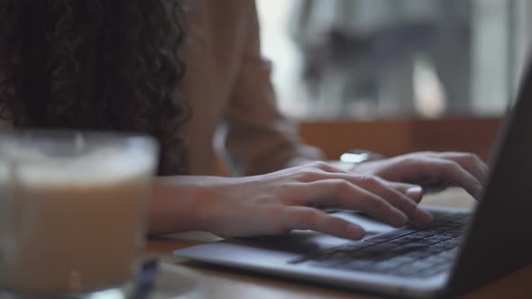 Girl Typing On Laptop Computer With Hot Coffee