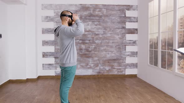 Caucasian Man Using Virtual Reality Headest in Empty Apartment