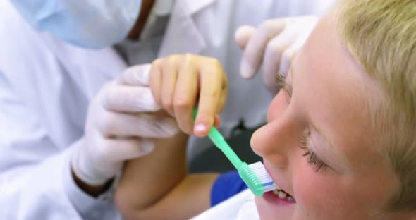 Dentist brushing a young patient's teeth