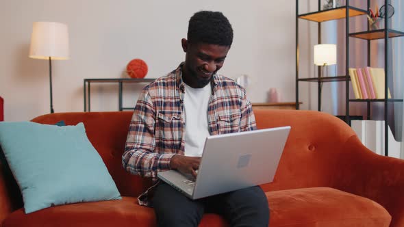 African American Young Man Sitting on Sofa Closing Laptop Pc After Work Online in Living Home Room