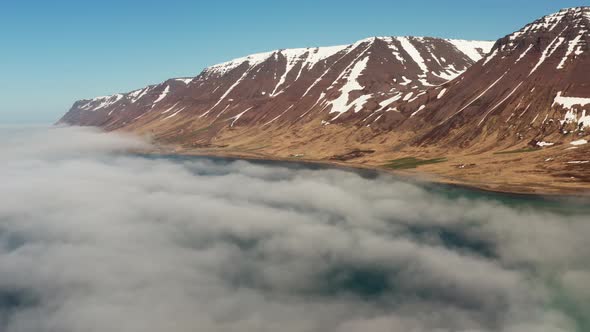 Drone Over Clouds Over Fjord Towards Mountains