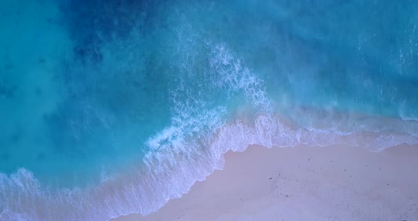 Daytime above clean view of a white sandy paradise beach and blue ocean background in colorful 4K