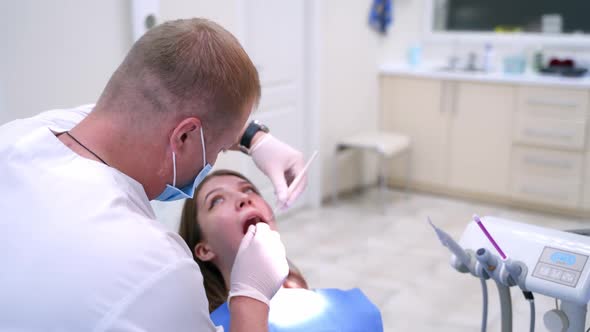 Doctor treats patient teeth in modern dental clinic. Health teeth concept.