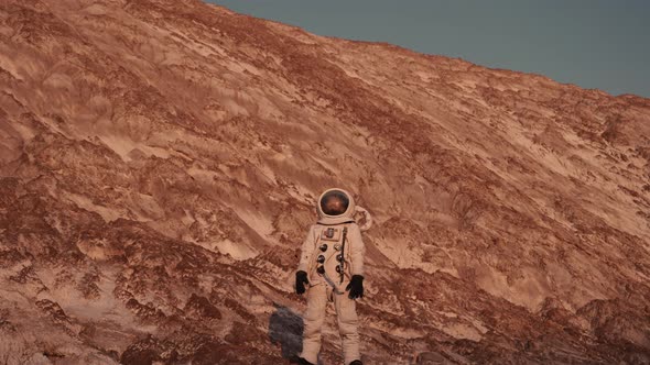 an Astronaut Stands on a Rock and Looks Into the Distance