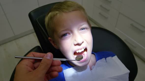 Dentist examining a young patient with tools