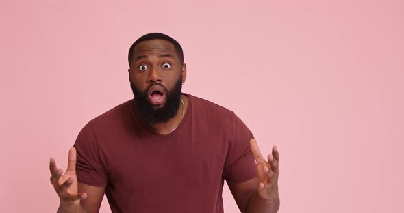 Young African American Man Yell and Point with Finger on Pink Background