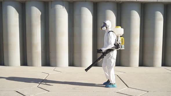 Disinfector in Protective Suit Processes Territory of Streets, Sprays Poison From Pests.