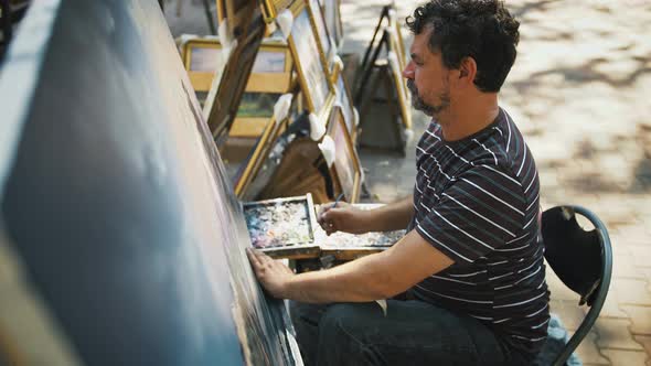 Gifted Male Artist is Drawing a Picture on Canvas Using Oil Paints