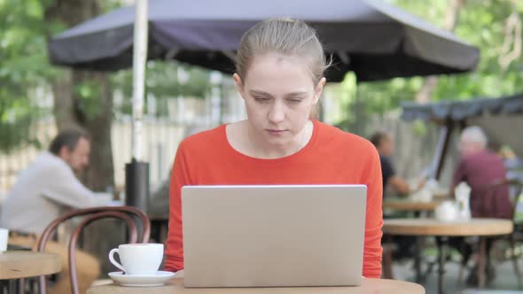 Young Woman Frustrated By Failure Sitting in Cafe Terrace