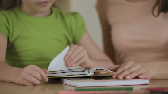 Mother and Little Daughter Reading Stories in Book Enjoying Leisure Together