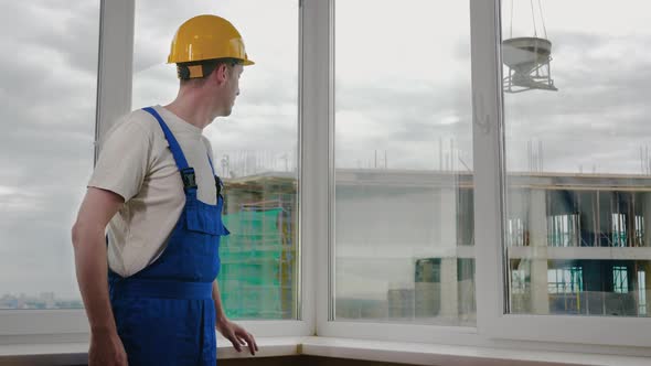 Serious Confident Worker with Arms Crossed Wearing Protective Helmet. Constructions Site.