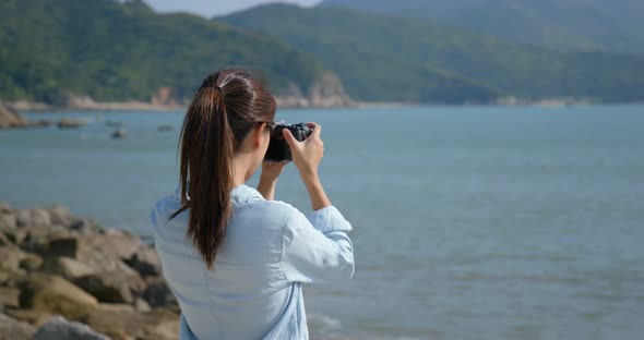 Woman take photo on camera on the sea