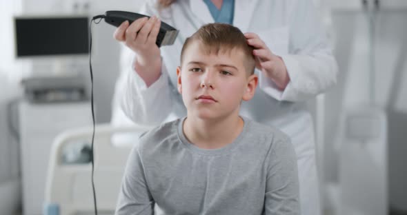 Nurse Shaving Teen Boy Before Chemotherapy in Hospital Ward