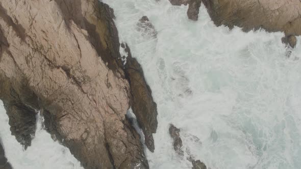 Aerial view of a small inlet being hit by the waves