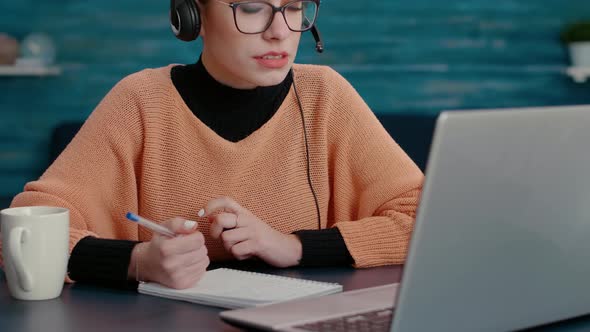 Young Adult Attending Teleconference Call on Laptop alt