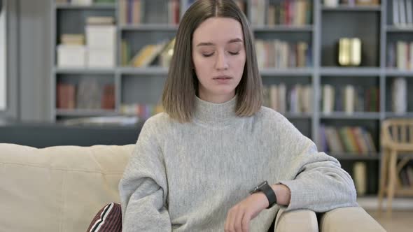 Portrait of Attractive Young Woman Waiting and Using Smart Watch