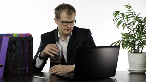 Tired Drunk Disheveled Businessman Working Hard in Office and Drink Alcohol