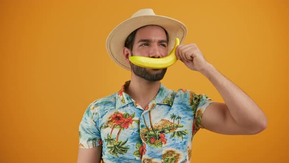 Handsome Latin Bearded Man in Beachwear Talking Through the Banana and Laughing Over Yellow