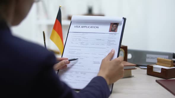 Immigration Inspector Denying Visa Application, German Flag on Table, Embassy