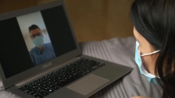 Woman in a Protective Mask Has a Meeting with a Man in a Protective Mask Via Video Call