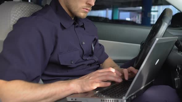 Patrolman Using Laptop to Check Road Situation in City, Online Criminal Database