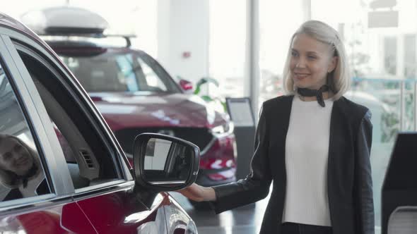 Lovely Woman Examining Cars for Sale at Dealership