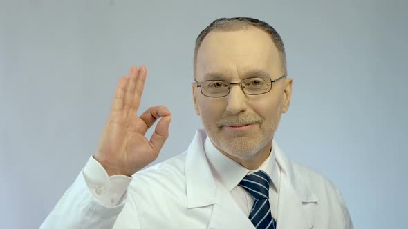 Male Physician Smiling, Showing OK Gesture, Sure of Successful Treatment Results