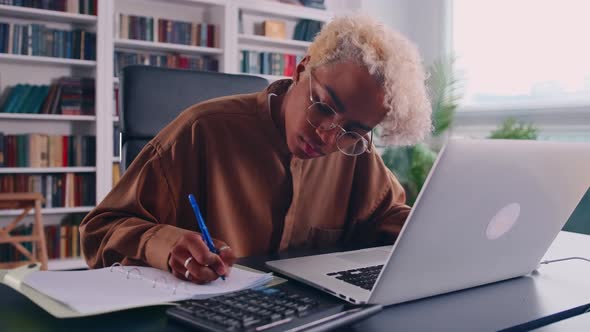 Young African American Woman Accountant Works with Laptop in Home Office