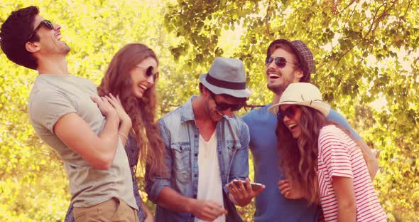 Happy Friends Watching Photos on a Smartphone in the Park