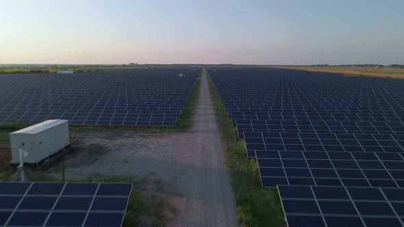Aerial Drone View Into Large Solar Panels at a Solar Farm at Sunny Summer Evening