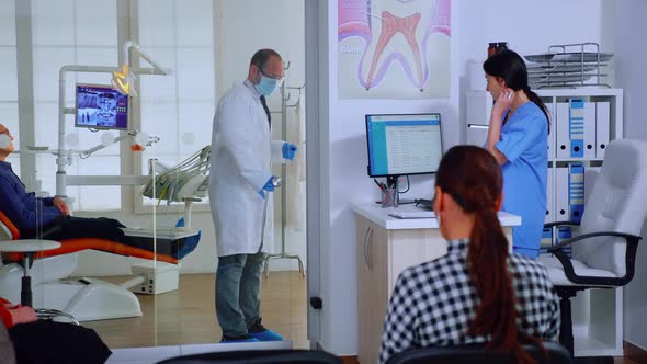 Dentist with Protective Mask Giving Teeth Xray to Nurse