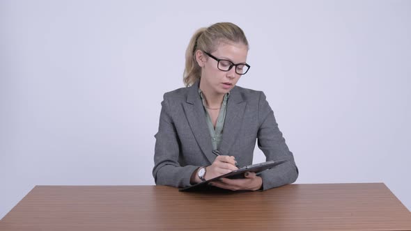 Young Stressed Blonde Businesswoman Looking Tired at Work