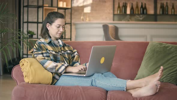 Content Woman Sitting With Laptop At Home