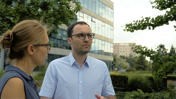 Business Man and Woman Talking Standing Near Office Building