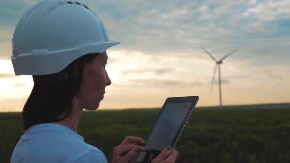 Woman Engineer Working in Wind Turbine Electricity Industrial at Sunset