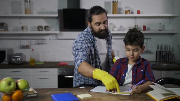 Busy Single Father Helping His Son with Homework