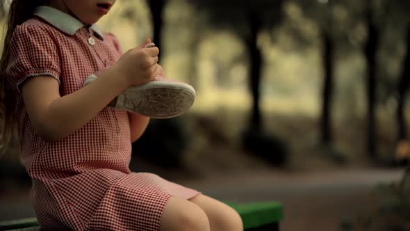 Little Kid  Sitting And Tying Sneakers Shoes. Girl Changing Shoes Before Playing With Father.
