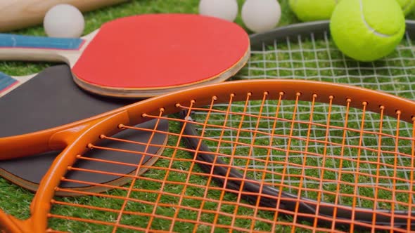 Sport Equipment Rackets and Balls on Grass Background