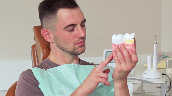 Handsome Young Man Smiling To the Camera Holding Dental Mold at the Clinic