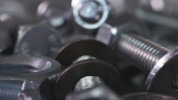 Slider Shot Video of Chrome Bolts and Nuts in a Chaotic Order Industrial Background