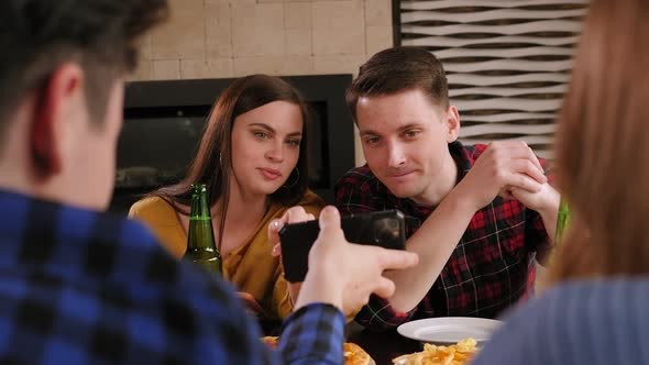 A Couple Is Relaxing in a Pizzeria a Guy Is Holding a Phone in His Hands