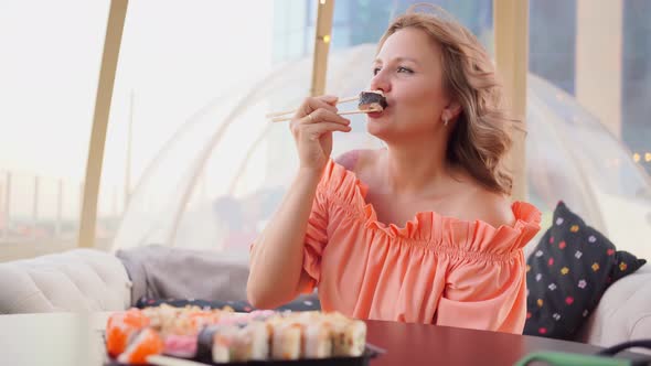 an Attractive Woman Eats Rolls with Sticks