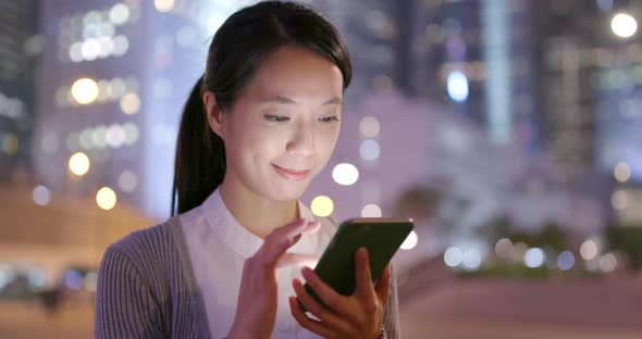 Asian Business woman use of mobile phone in city at night