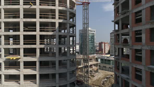 Aerial shot of construction of high-rise apartment buildings and cranes in city 15