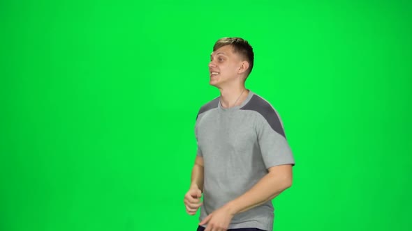 Young Man Runs on a Green Screen. Slow Motion